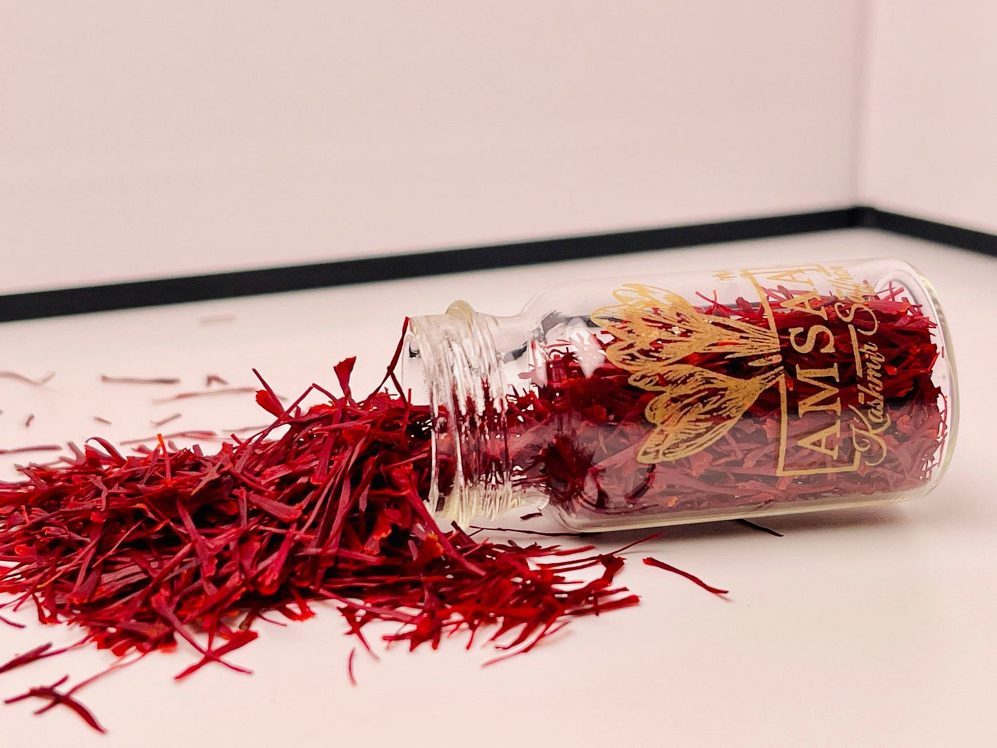 Amsaa Kashmir Saffron 1 Gram jar tipped over with red saffron threads spilling out